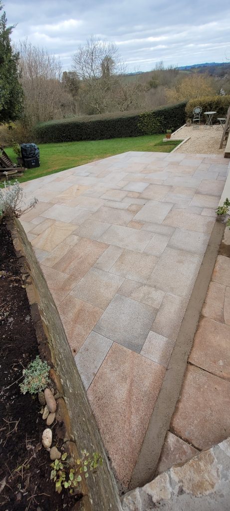 Yellow limestone patio with Cotswold walling and resin jointing in Chilcompton