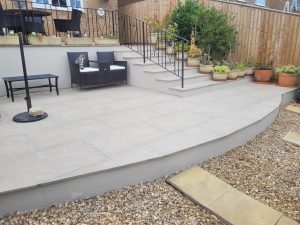 Porcelain patio installation in Midsomer Norton with ivory cream paving and steps, complemented by rendered walls for a bright and crisp finish