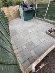 Beautifully landscaped garden in Bath with sandstone grey paving, raised planter, and fence panels